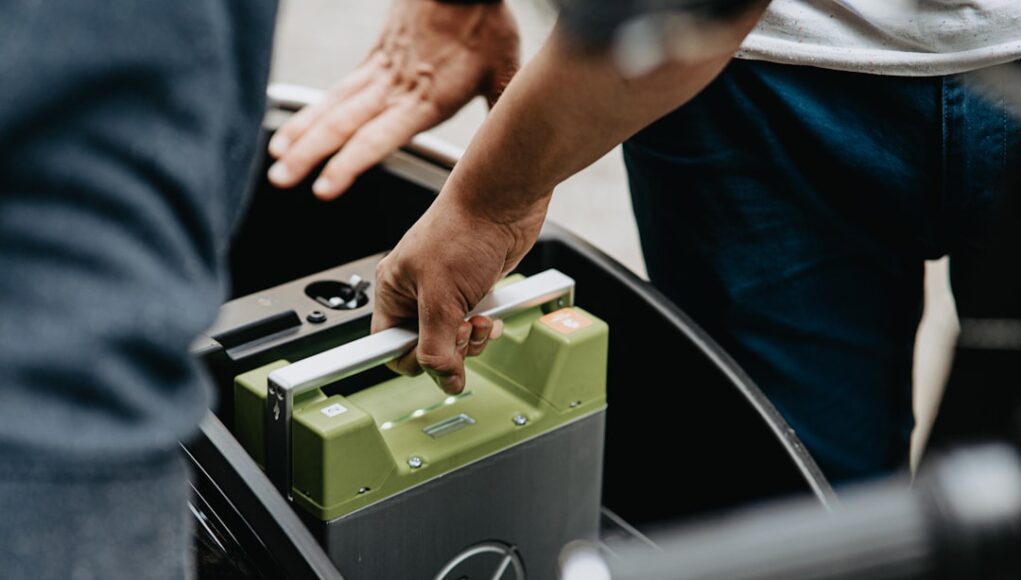person holding black and green electronic device
