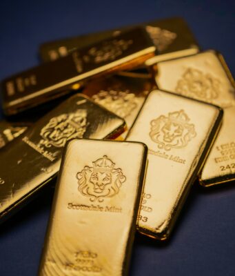 Goldpreis knackt 5000-Dollar-Marke erneut A pile of gold bars sitting on top of a table