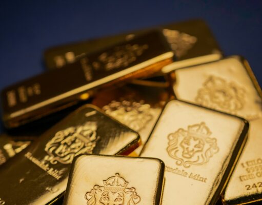 Goldpreis knackt 5000-Dollar-Marke erneut A pile of gold bars sitting on top of a table