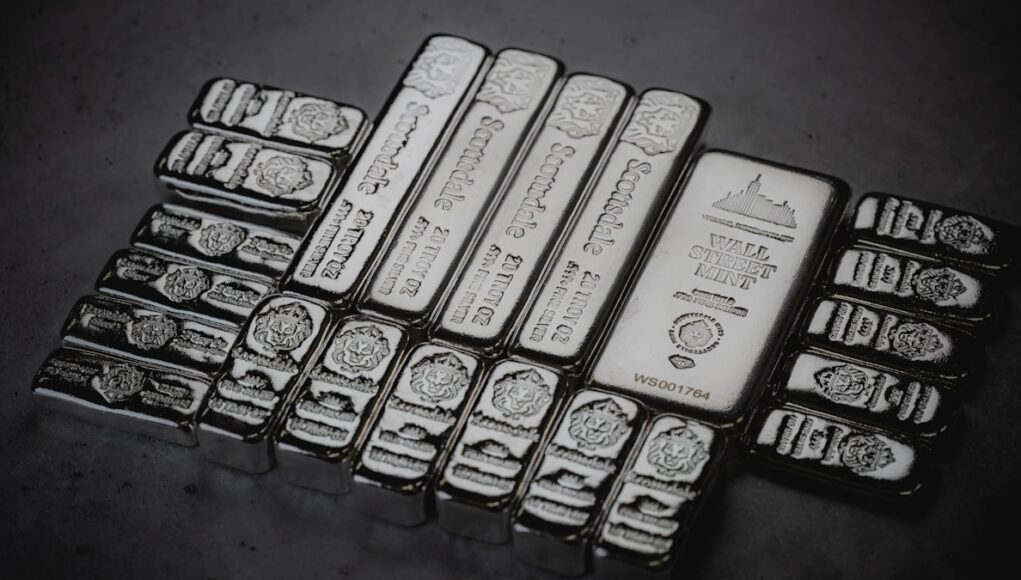 Scottsdale Mint cast silver bars stacked in a pile. a pile of silver bars sitting on top of a table