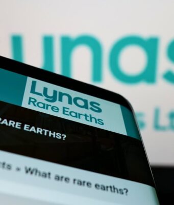 Lynas Rare Earths-Aktie +8%: Feiert sie jetzt ihr Comeback? Close-up of a smartphone displaying the Lynas Rare Earths website with the Lynas sign blurred in the background.