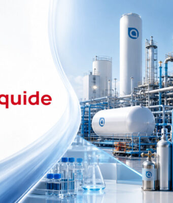 Air Liquide-Aktie: Um 165 € wieder kaufen? Air Liquide logo on the left with a blue-and-white industrial gas plant featuring tanks, pipes, and a wind turbine in the background.