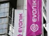 Evonik-Aktie: Ist die Sonderkonjunktur nachhaltig? White and magenta banners on a modern building, displaying the Evonik logo and the slogan 'Leading Beyond Chemistry'.