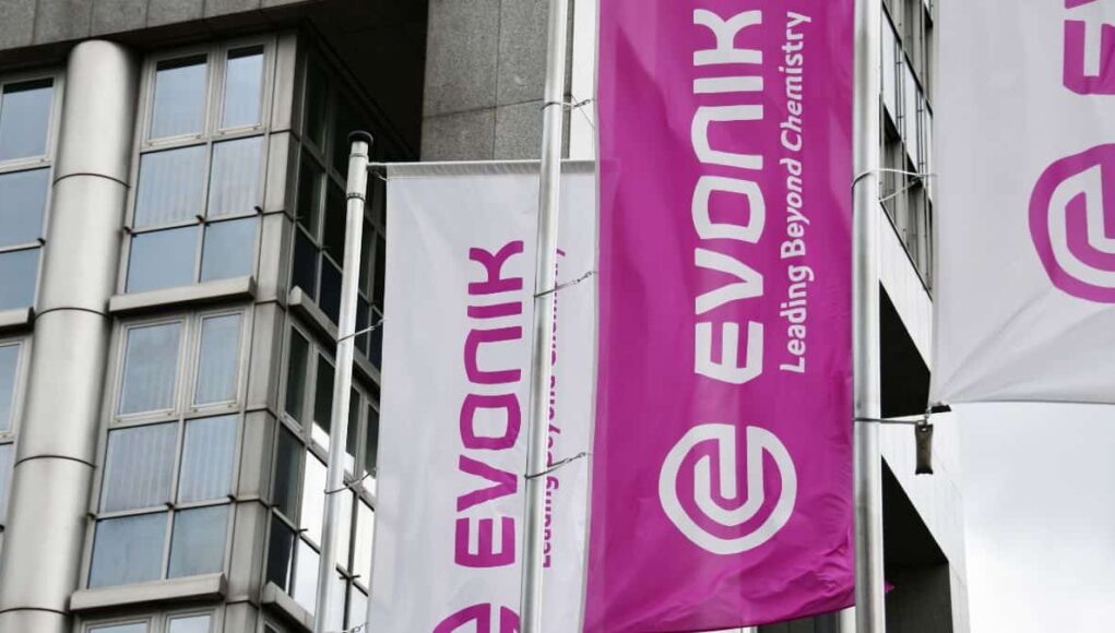 Evonik-Aktie-Ist-die-Sonderkonjunktur-nachhaltig.jpeg White and magenta banners on a modern building, displaying the Evonik logo and the slogan 'Leading Beyond Chemistry'.