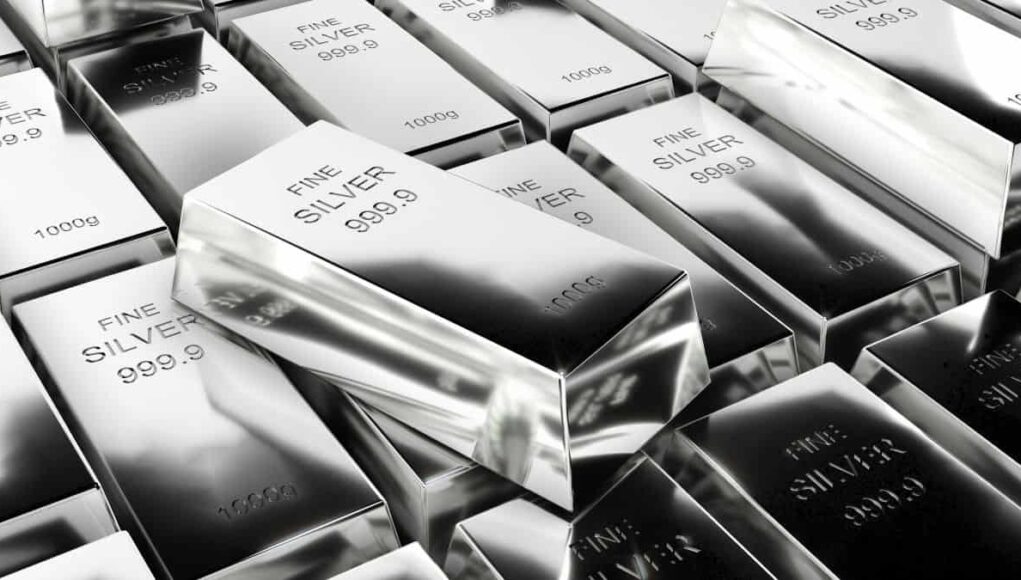 Stack of silver bullion bars stamped 'FINE SILVER 999.9' in a reflective pile