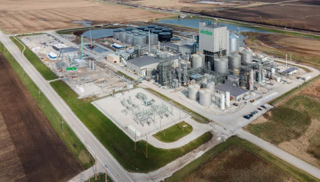 Verbio-Aktie-Ertragsprognose-getoppt-–-was-kommt-jetzt.jpeg A Verbio biorefinery with numerous storage tanks and processing towers in a rural industrial site surrounded by fields.