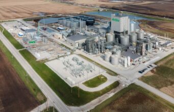 Verbio-Aktie: Ertragsprognose getoppt – was kommt jetzt? A Verbio biorefinery with numerous storage tanks and processing towers in a rural industrial site surrounded by fields.