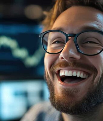 Energy Transfer-Aktie +30% und Dividende: Unser Top-Tipp entwickelt sich prächtig Close-up of a smiling man with a beard and black-rimmed glasses in a high-tech workspace.