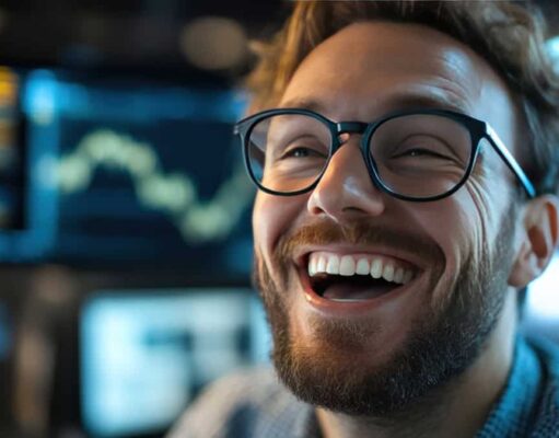 Energy Transfer-Aktie +30% und Dividende: Unser Top-Tipp entwickelt sich prächtig Close-up of a smiling man with a beard and black-rimmed glasses in a high-tech workspace.