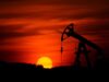 Obsidian Energy: Erdöl-Aktie mit Kurspotenzial Silhouette of an oil pumpjack against a red-orange sunset horizon.