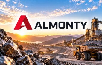 Almonty-Aktie mit -44% – lohnt sich jetzt der Einstieg? Almonty logo over a rock mining site with dump trucks and conveyor belts at sunrise/sunset.
