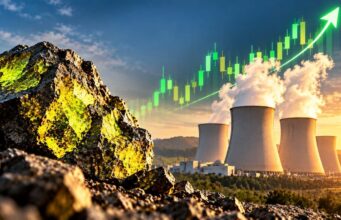 Cameco-Aktie stark gefallen – Anleger wittern neue Chancen Rugged rocks in the foreground with a power-plant cooling towers and rising green stock-chart line in the sky, signaling growing energy investment.