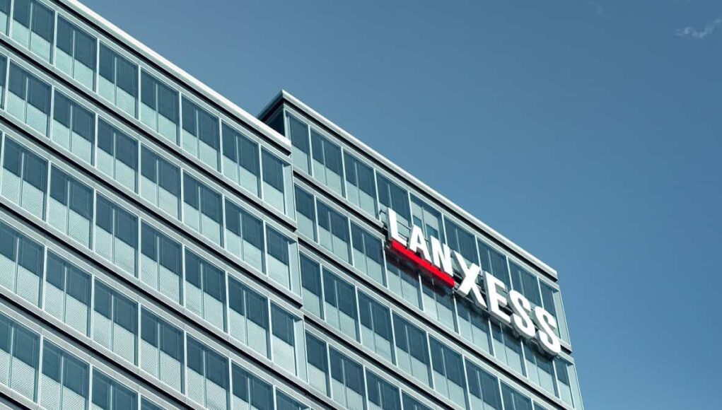 Lanxess-Aktie-Koennen-diese-Faktoren-die-Kurswende-bringen.jpeg Modern glass office building with a LANXESS sign on the facade against a blue sky