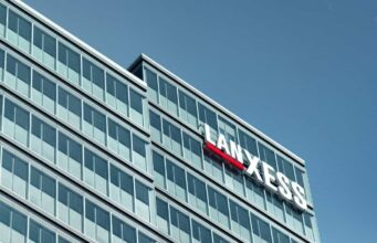 Lanxess-Aktie: Können diese Faktoren die Kurswende bringen? Modern glass office building with a LANXESS sign on the facade against a blue sky