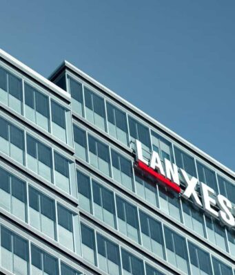 Lanxess-Aktie: Können diese Faktoren die Kurswende bringen? Modern glass office building with a LANXESS sign on the facade against a blue sky