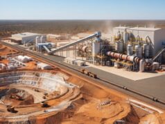 Lynas Rare Earths-Aktie -7%: Warum die miese Laune? Open-pit mining and processing plant in a desert landscape with conveyors, silos, and heavy machinery nearby rail tracks.