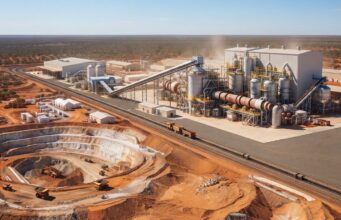 Lynas Rare Earths-Aktie -7%: Warum die miese Laune? Open-pit mining and processing plant in a desert landscape with conveyors, silos, and heavy machinery nearby rail tracks.