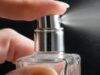 Symrise-Aktie +40% seit Jahresanfang: Was könnte jetzt ratsam sein? Close-up of a hand pressing a perfume spray nozzle and releasing mist from a glass bottle