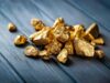 Goldminen-Aktien: 17,4 % Gewinn trotz Gold-Crash – jetzt einsteigen? A pile of gold nuggets sitting on top of a wooden table
